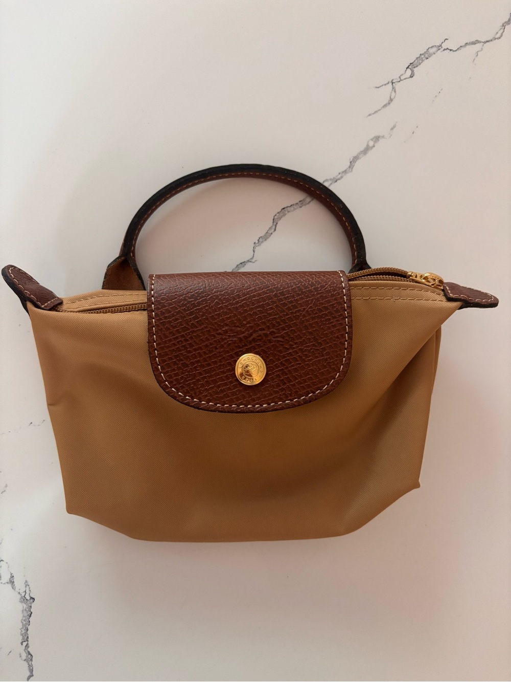 Compact Longchamp small top-handle mini bag in tan with brown trim